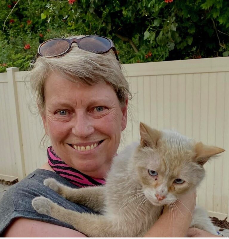 Julie Davis holding a gray cat outdoors